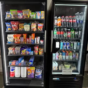Two glass-front coolers side by side, the left one stocked with snacks and the right one with drinks